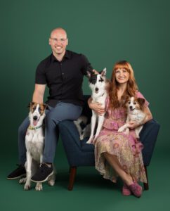 family portrait with 3 dogs on a green studio backdrop