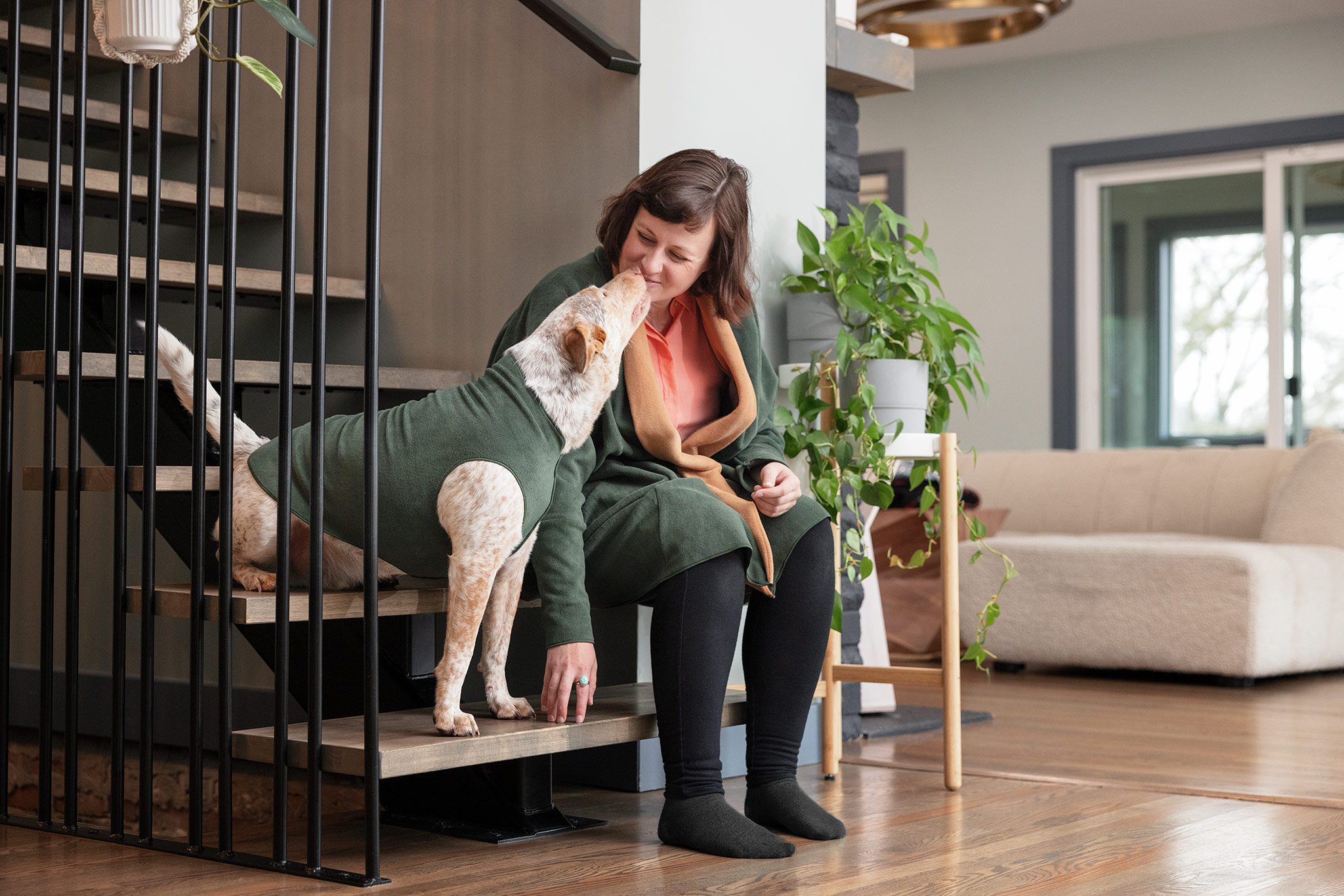 woman and dog sitting on steps in goldpaw fleece